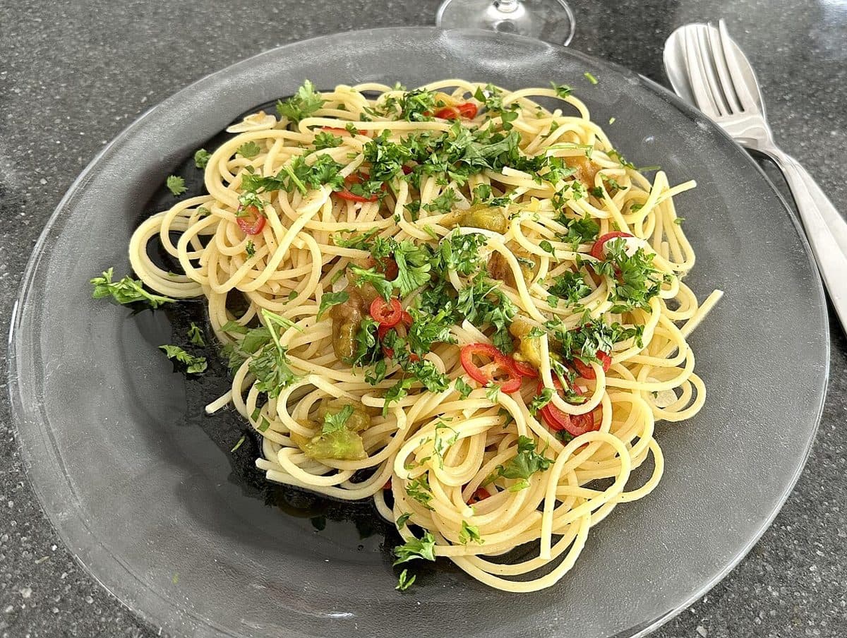 Spaghetti aglio e olio z natką pietruszki i chili na talerzu